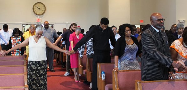 Members of the Oakland Church of Christ in Southfield, Mich., hold hands as they pray for racial reconciliation at the 50th anniversary of the Detroit riot in 2017.