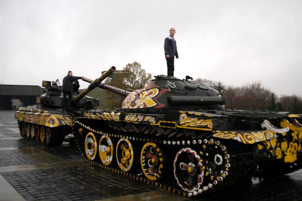 Children play on Cold War-era tanks, decorated with flowers and emblems of peace, In Kyiv, Ukraine, in 2003.