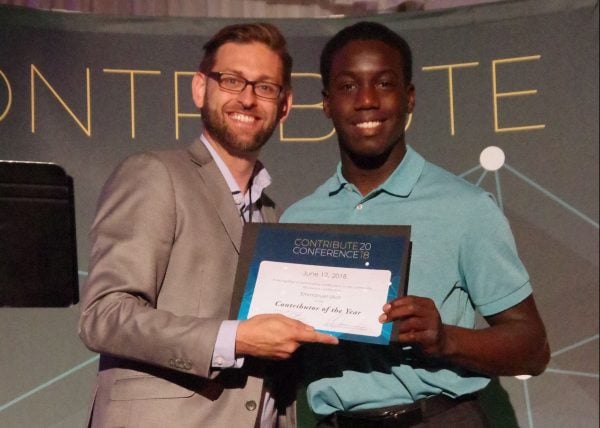 Emmanuel Ukot accepts an award from Brandon Tatum at the Contribute conference.