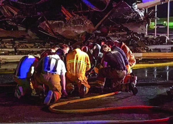 Volunteer firefighters take time to pray after battling the church fire in Kermit, Texas.