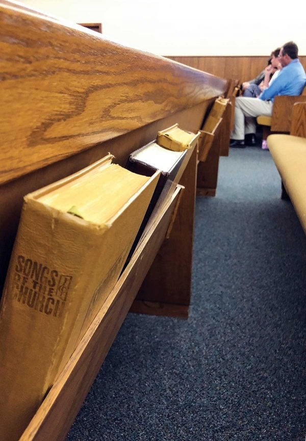 Hymnals line the pews of the Kress Church of Christ. The church, which has seven regular worshipers, swelled to 73 during a recent Homecoming Sunday.