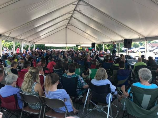 Memorial Drive members meet under a tent after their building burned in 2019.