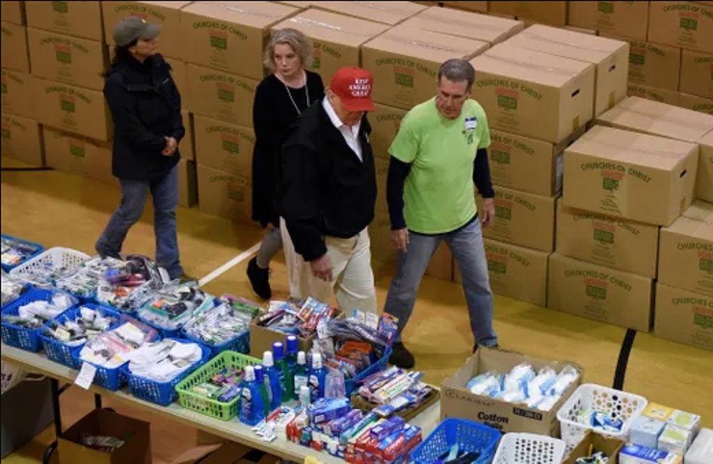 President Donald Trump walks with Laura Bates, Rick Gilbert and Tennessee First Lady Maria Lee, left, at a supply distribution center at Jefferson Ave. Church of Christ in Cookeville, Tenn., during his visit to tornado-ravaged areas in the state.