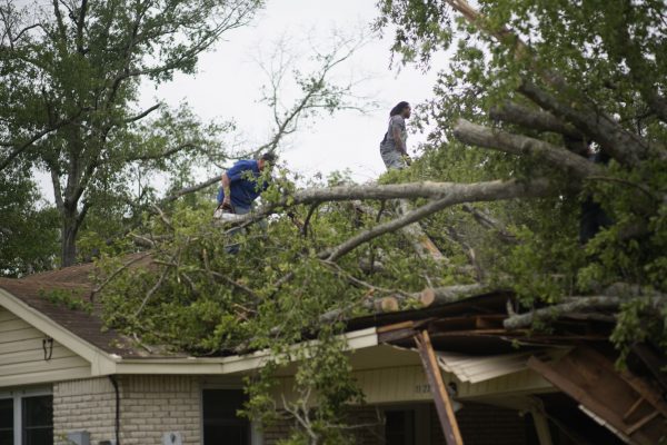 One Kingdom volunteers work of the roof of a house after tornadoes hit the Monroe, La., area.