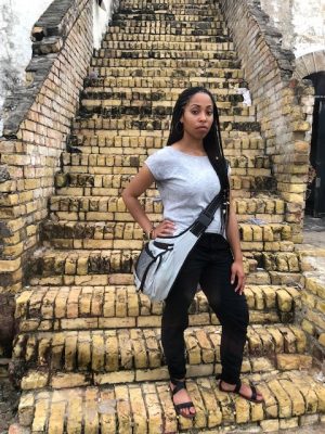 Ashley Moneet Williams stands on the steps of the Cape Coast Castle in the African nation of Ghana.