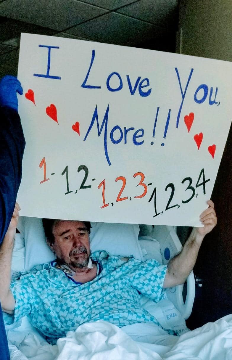 Marty Neal holds a sign up in a hospital window showing his family which room he was in.