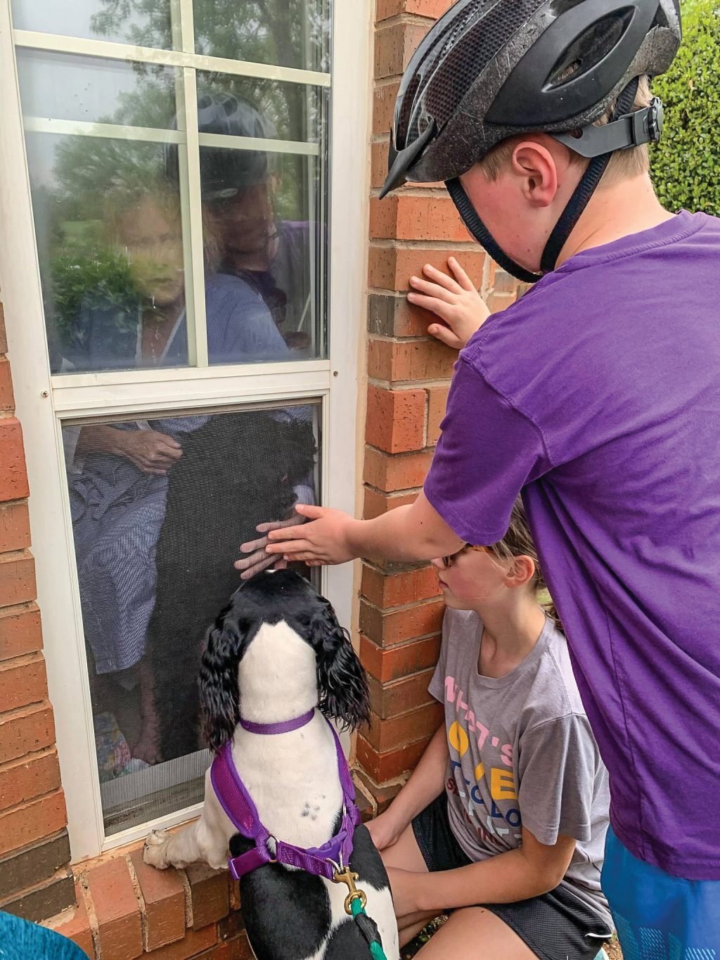 Knox Watson and his grandmother, Judy Forrester, press their hands against a window at Tealridge, an independent living facility in Oklahoma City, as they say goodbye. Watson’s sister, Nora, and their dog, Mae, also came to see Forrester, 72. “She hasn’t been able to hug them since March,” said Forrester’s daughter, Amanda Watson, events coordinator for Oklahoma Christian University. “She is lonely but doing good.”