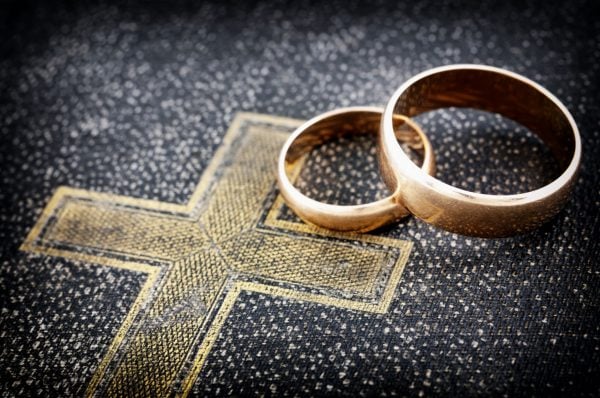 Two wedding bands lay atop a Bible.