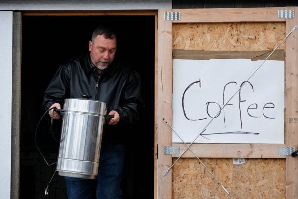 Rob Smith carries a coffee pot out of the "horse barn" used to store disaster relief supplies at his wife Penny's business.