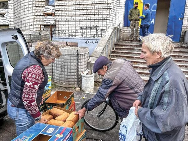 After Russia’s retreat, hungry Ukrainians in the city of Izium take loaves of bread delivered by Volunteer Brothers.