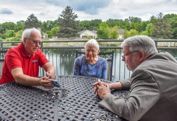 Willow Brook CEO Larry Harris, right, visits with independent living residents Bob and Mary Holm.