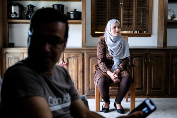 Azizah Hashemi listens to her husband, Mohammad, share stories about their escape from Afghanistan.