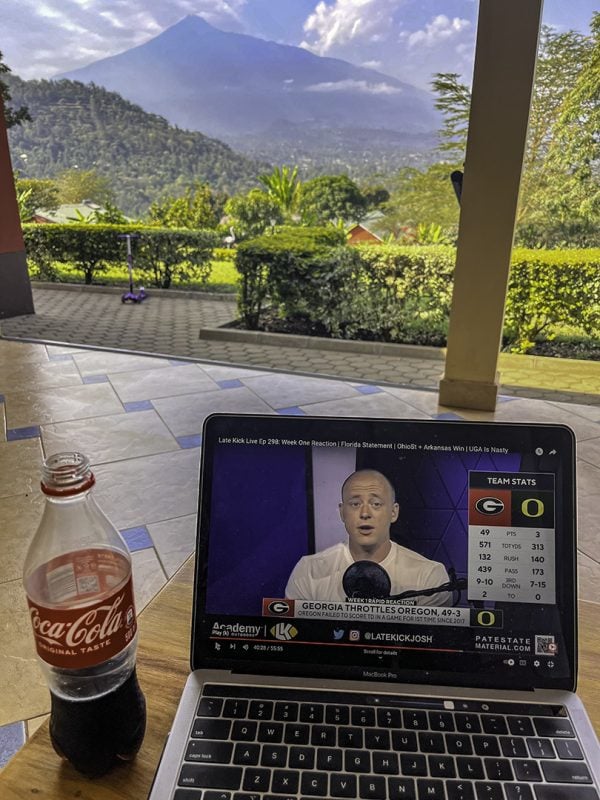 From the porch of a guest house in Neema Village in Arusha, Tanzania, Erik Tryggestad watches Josh Pate discuss UGA's 49-3 rout of Oregon.