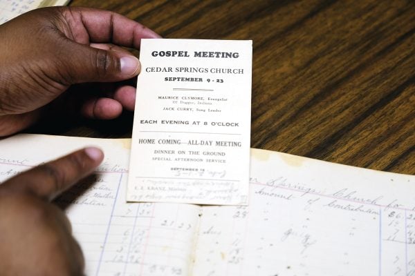 Zack Martin holds an archived gospel meeting invitation from decades ago.