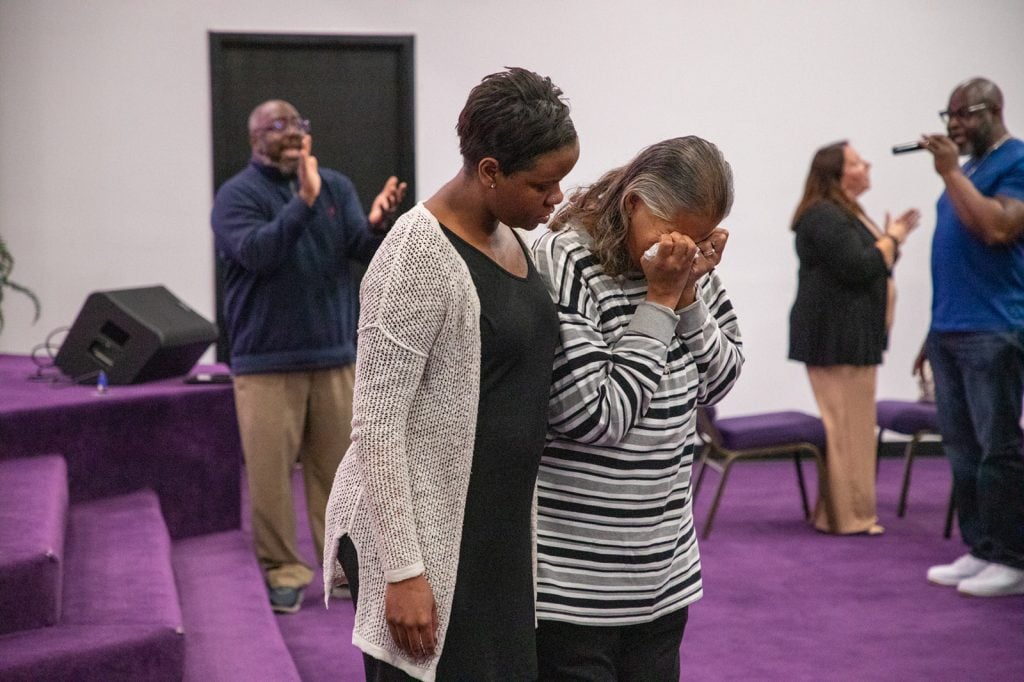 A woman becomes emotional after responding to the invitation at the Greater Metropolitan Church of Christ in Kansas City, Mo.