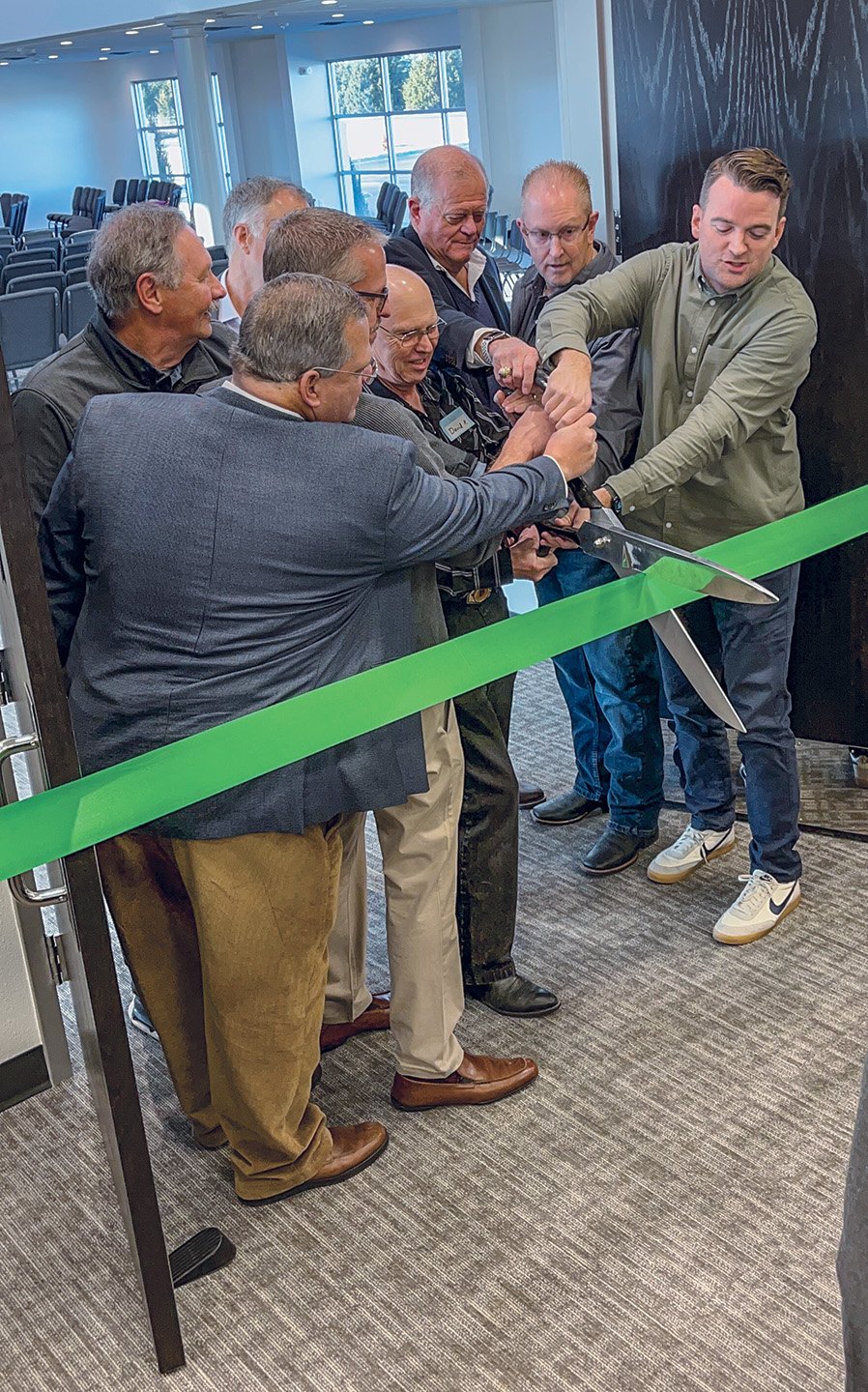Minister Travis Akins, right, elders of the Heritage Church of Christ and a representative of the company that built the church building cut a ribbon during Heritage's grand opening service.