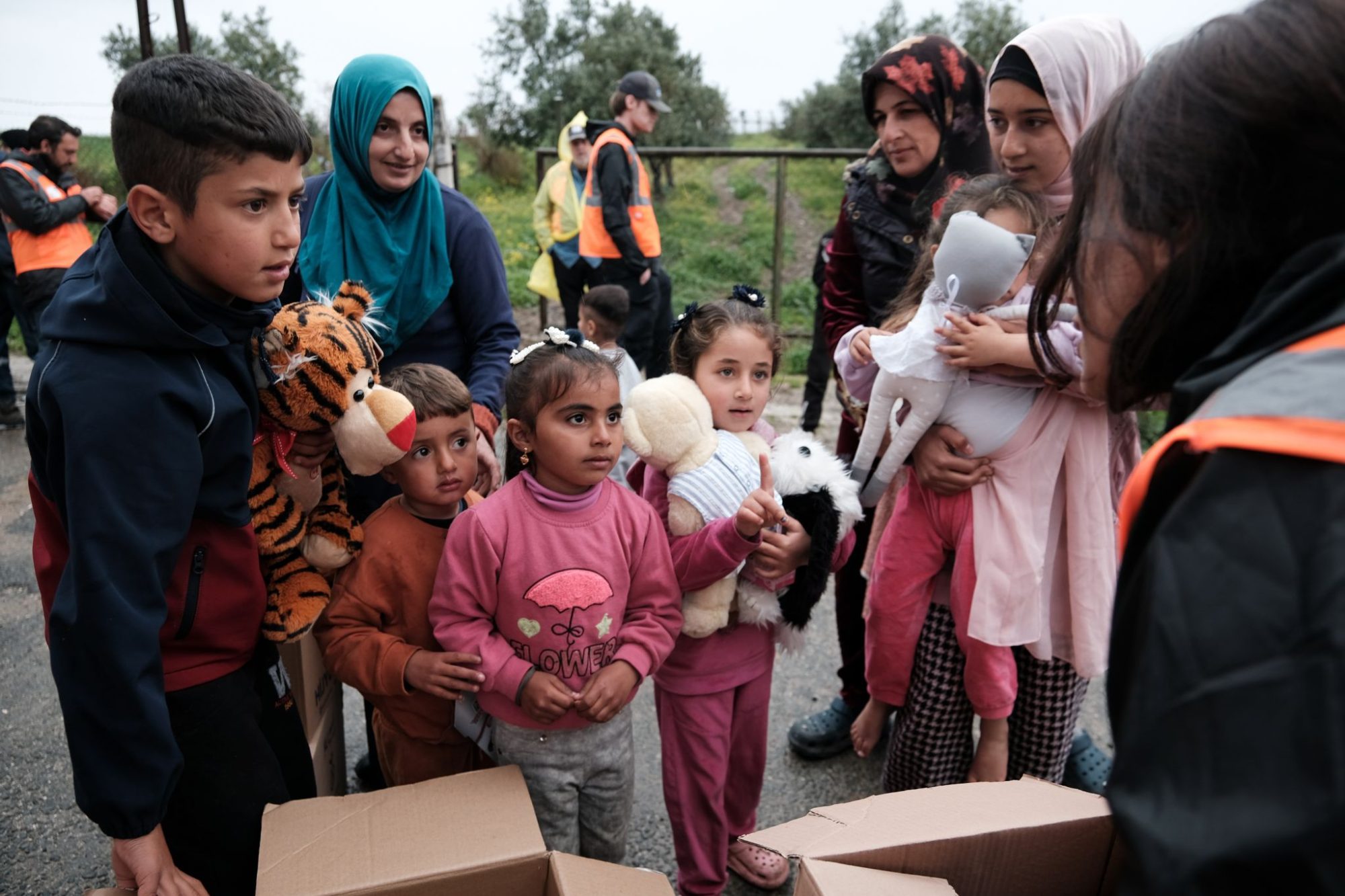 Children wait in line for nonessential items — stuffed animals, puzzles and plastic cars — during a supply distribution campaign.