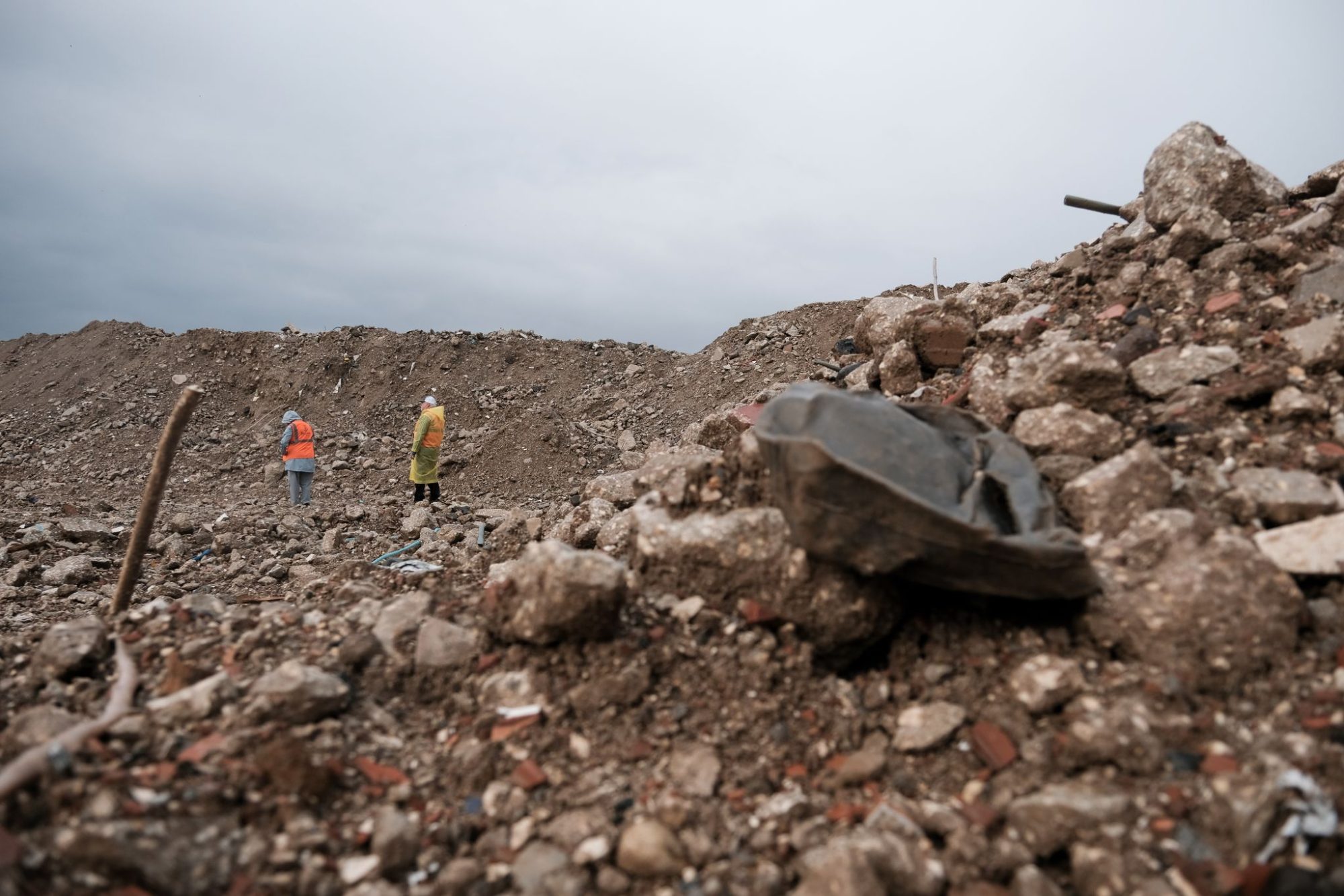 Beverly Dobbs and Robert Ables walk through the rubble of a residential neighborhood in Antakya, Turkey, over a year after its destruction on Feb. 6, 2023.