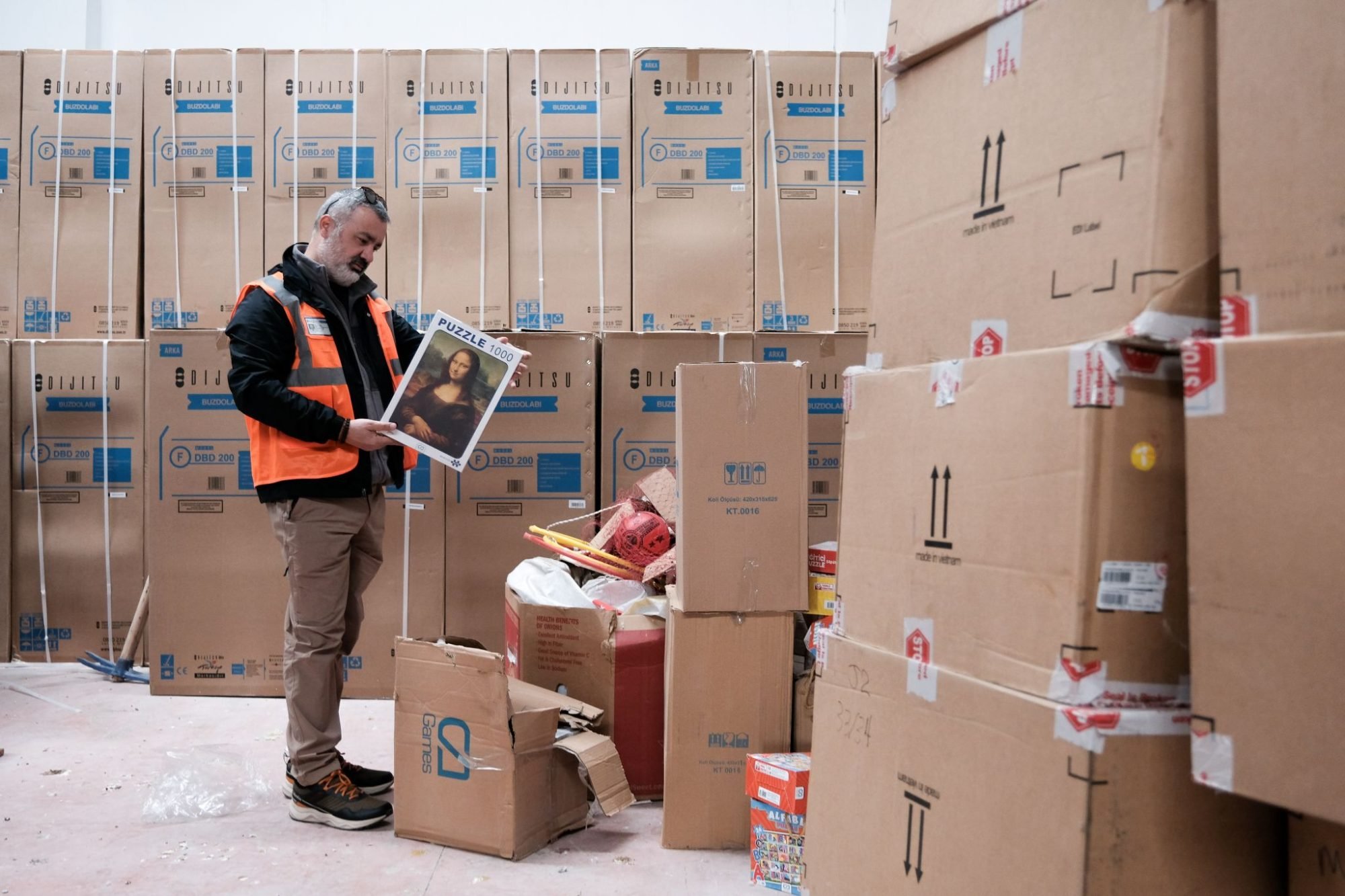 Refik Topcu, İlk Umut Derneği’s vice chairman of the board, inspects puzzles at a warehouse that will be distributed to children living in temporary housing.