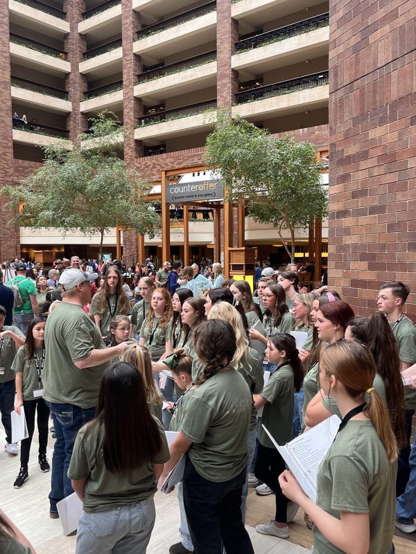 A chorus practices in the atrium of the Hilton Anatole during the 2024 North Texas Leadership Training for Christ convention.