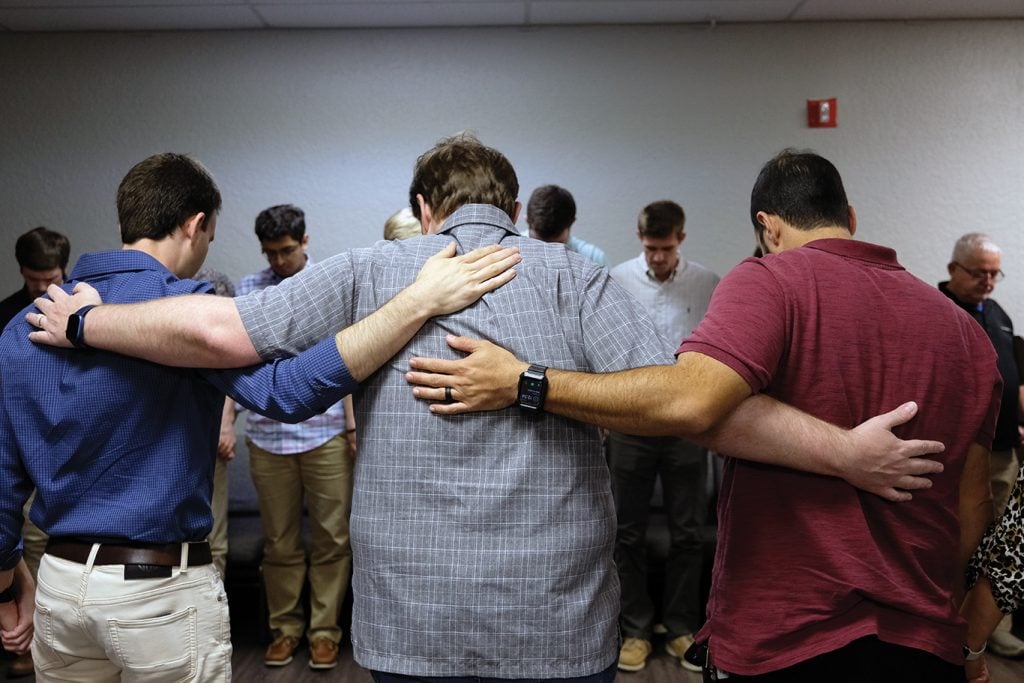 Maikon Borba, center, prays with Mexican, Brazilian and American Christians.