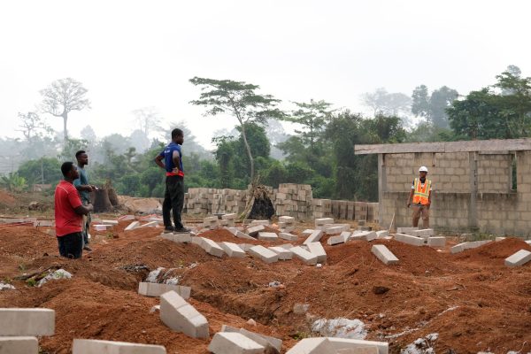 Foreman Koo Redd, right, discusses the construction of a new girls' boarding school in New Debiso with men from the surrounding area. 