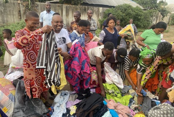 Richard Inyang, in the white T-shirt, distributes clothes on a past mission trip to Nigeria and Cameroon.