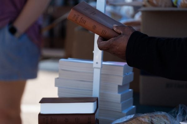 A guest picks up a free Bible during the regular Saturday food giveaway of the Bridgewood Church of Christ.