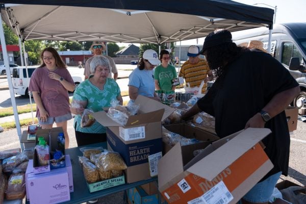 A guest picks out a free loaf of bread during the Bridgewood Church of Christ's regular Saturday food giveaway.