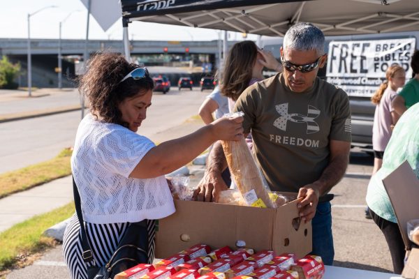 Federico Sandatte, left, and his wife, Amalia Sandatte, look through a box of bread during the Bridgewood Church of Christ's regular Saturday giveaway.