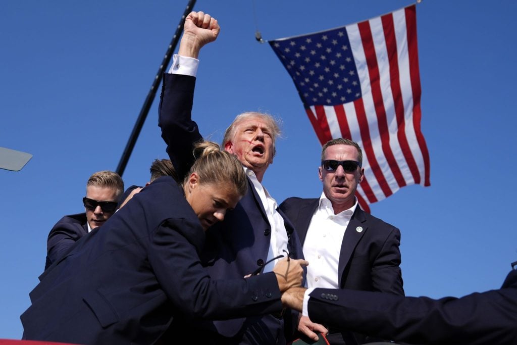 Former President Donald Trump is surrounded by U.S. Secret Service agents at a campaign rally, Saturday in Butler, Pa.