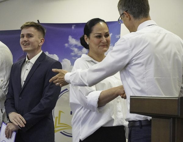 Larysa Dekhiarova receives her diploma from Ukrainian Bible Institute director Brandon Price. At left is fellow graduate Roman Hadlevskyi.