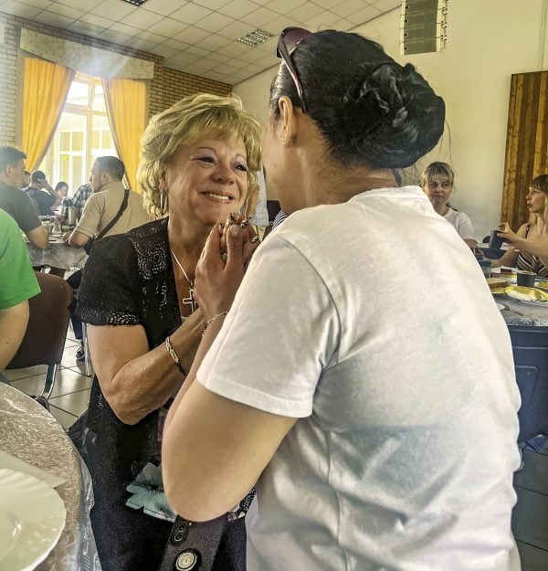 Mary Lee Rogers, left, greets Larysa Dekhiarova during breakfast at a Christian retreat center in Irpin, Ukraine.