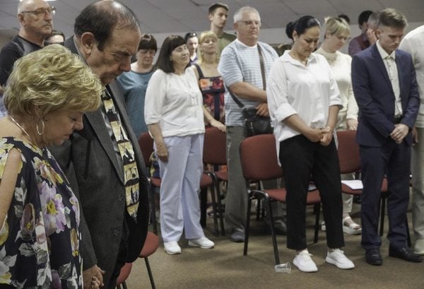 Mary Lee and Jay Don Rogers, left, pray with Ukrainian Bible Institute students and their families.