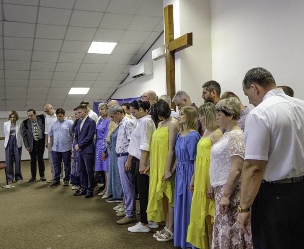 Alexander Maliuga, right, a Ukrainian Bible Institute instructor, leads a prayer for students past and present.