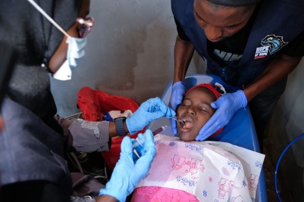 A girl gets a tooth pulled by Hope Springs International dental staff.