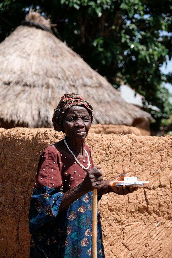 An elderly women carries the medicine she received at a Hope Springs International clinic back to her mud house in Dongol, Nigeria.