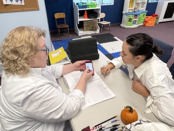 Janet Lallathin uses her phone to assist English translation.