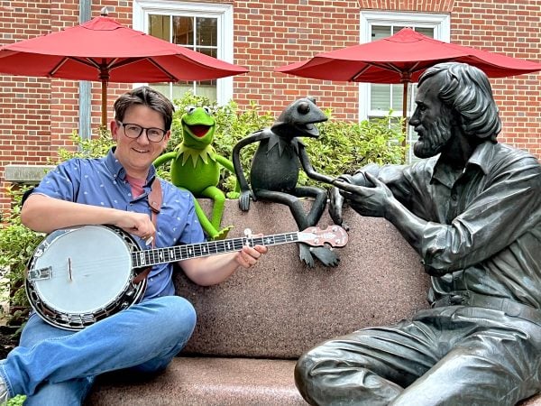 Lucas Ross and Kermit the Frog sit on a bench dedicated to the late Jim Henson on the campus of the University of Maryland.