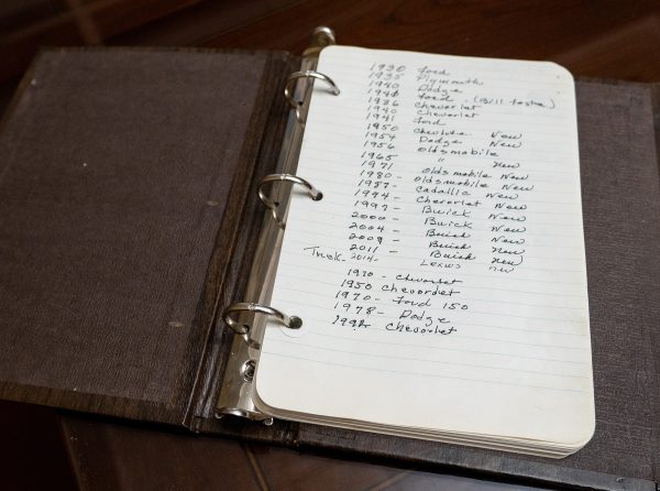 A nondescript notebook condenses into one page a lifetime of auto and truck ownership by the Huckabys, mirroring a similar list of the homes the couple bought together.