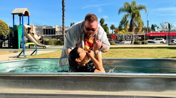 Grey Powell, lead minister for the Long Beach Church of Christ, baptizes a newly converted believer in the courtyard outside the church building.