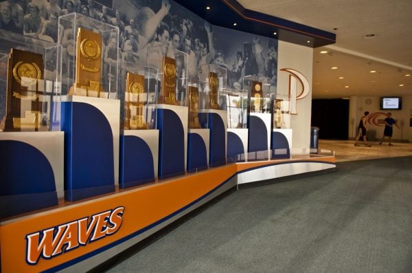 A trophy wall features Pepperdine University’s Waves logo.