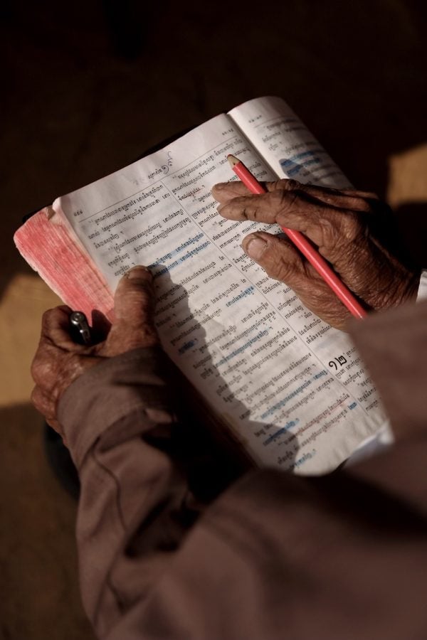 A Cambodian Christians reads a well-worn Bible during Sunday worship.