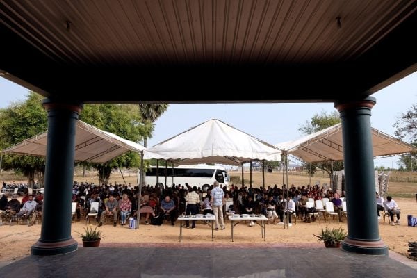 Cambodian and American Christians meet under tents for Sunday worship.