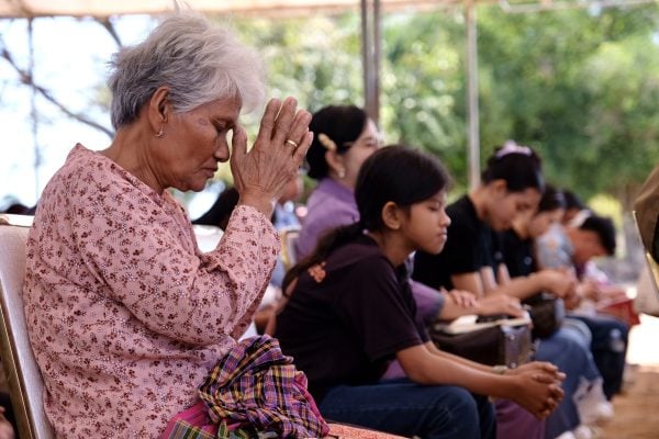 A woman prays during a Sunday worship service in Preah Netr Preah, Cambodia.