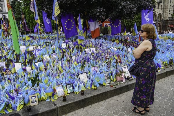 Inna Kuzmenko, a Ukrainian from Kharkiv who has relocated to Ivano-Frankivsk since the war began, stands next to a field of flags in downtown Kyiv commemorating lives lost during the conflict.