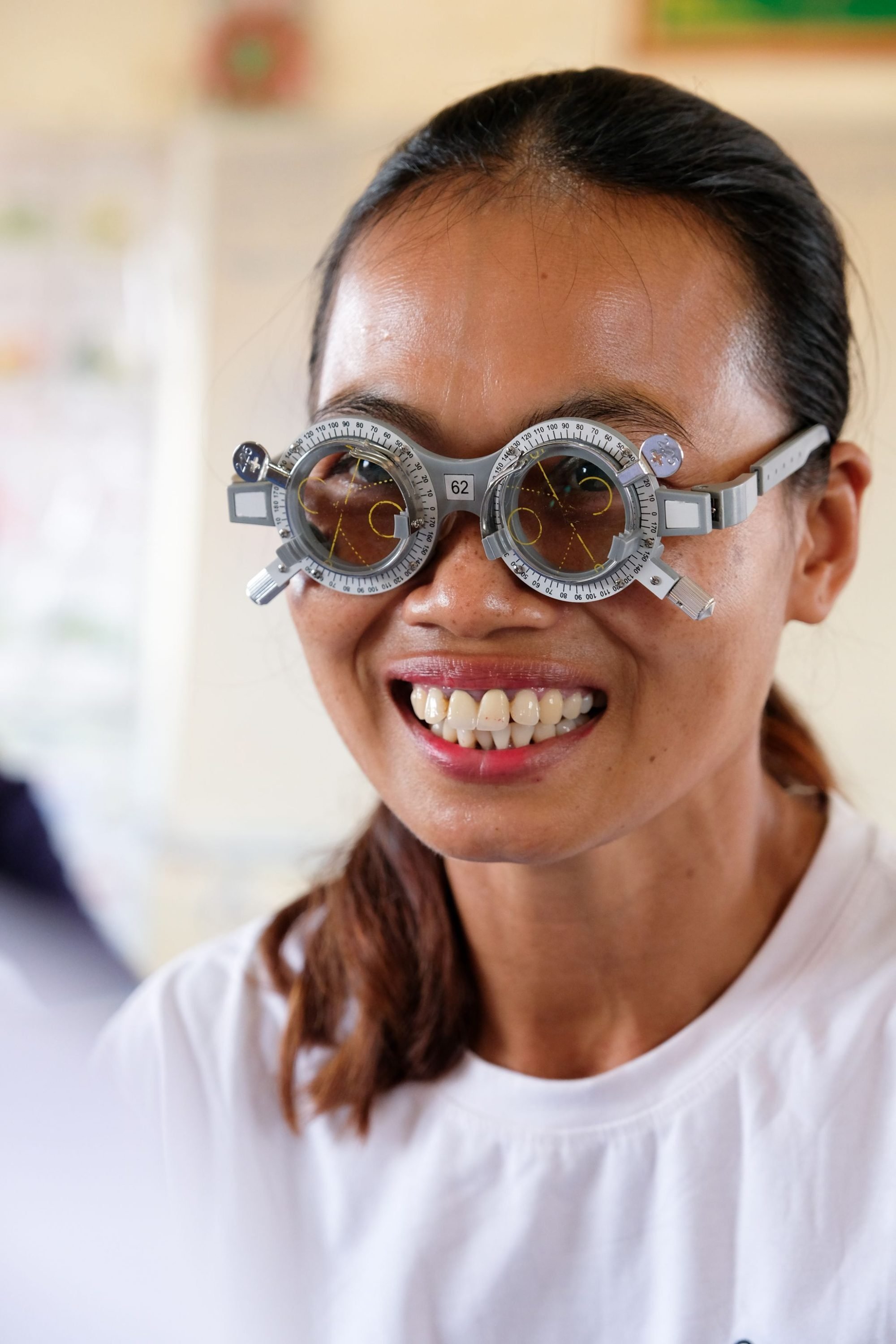 A patient smiles during an eye exam in Prey Svay, Cambodia.