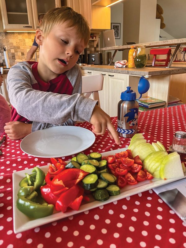 At a breakfast gathering, Sam Anderson points to tomatoes grown in his family’s garden.