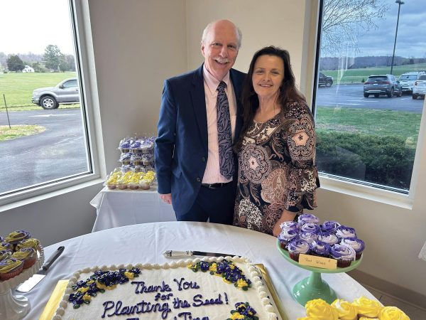 W. Tom Hall and his wife, Tina, stand next to a cake that reads, “Thank you for planting the seed!”
