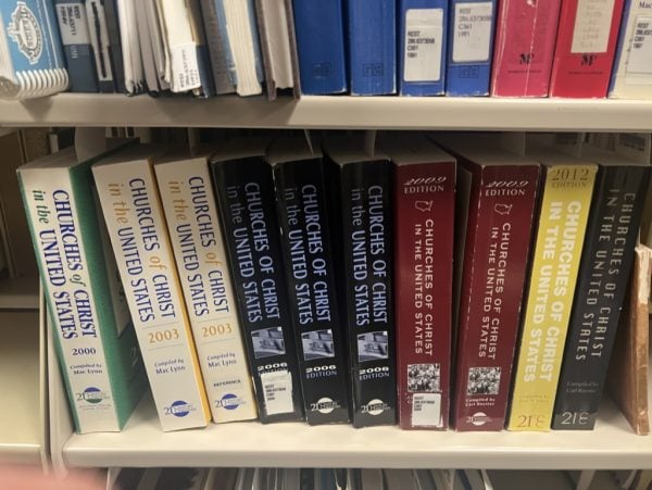 Previous editions of "Churches of Christ in the United States" sit on a bookshelf.